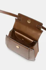 Bolso de mano tipo city color marrón, con diseño estructurado, costuras a la vista en color blanco y detalles de hebillas metálicas decorativas en la parte frontal. Cuenta con asa de mano superior, correa ajustable para usar como bandolera y cierre mediante solapa con imán.