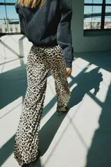 Pantalón de tiro medio con estampado animal print de leopardo, cintura elástica ajustable con cordón y perneras amplias y rectas.