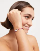 Pulsera de hilo color malva con perla shell y fornitura bañada en plata de ley.