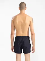 Short de baño para hombre color azul marino, con calce relajado y una tira lateral blanca estilo tuxedo. Presenta cintura elástica con cordón regulable, bolsillos laterales y trasero con cierre.