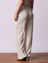 Pantalón cargo de lino a rayas verticales grises y blancas, marca Marissa Olivia. Pretina ancha elastizada con lazo de ajuste, bolsillos inclinados delanteros y bolsillos laterales con botón.
