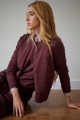 Cardigan azul de punto fino, con cuello redondo y cierre frontal de botones negros.