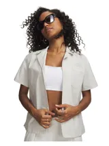 Camisa de manga corta con cuello solapa y cierre frontal de botones. Presenta un diseño minimalista con un bolsillo aplicado en el pecho izquierdo y un corte recto.