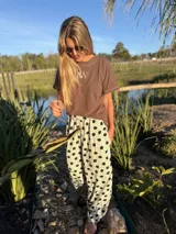 Remera color beige de algodón, con cuello redondo y logo 'AW' bordado en el frente.