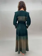 Vestido largo verde con efecto degradado, mangas largas abullonadas y falda con tajos laterales.