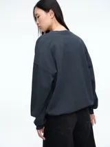 Buzo de algodón color gris oscuro, con cuello redondo, mangas largas y puños elásticos. Presenta la palabra LOVE estampada en el frente con aplicaciones de lentejuelas rojas.