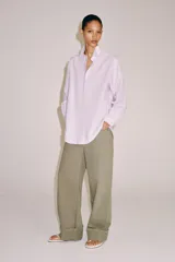 Camisa de manga larga confeccionada en hilatura con mezcla de algodón, con cuello solapa, bajo redondeado y cierre frontal oculto con botones.