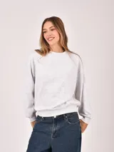 Buzo de cuello redondo en color gris melange, con diseño de corte holgado y mangas largas con puños elásticos.