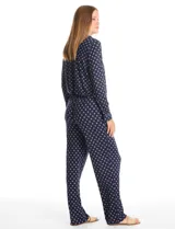 Conjunto de pijama de dos piezas con estampado animal print. La parte superior es una camisa de manga larga con cuello solapa, escote en V, cierre frontal con botones y bolsillo aplicado. El pantalón cuenta con cintura elástica y lazo de ajuste.