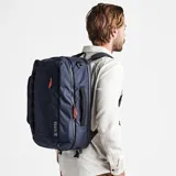 Mochila azul con detalles en negro y naranja, con dos compartimentos plegables con cierre, solapas de malla con cierre, bolsillo acolchado para computadora portátil y bolsillo oculto para pasaporte.