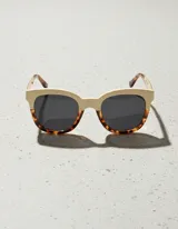 Lentes de sol cuadrados con armazón bicolor: parte superior color crema y parte inferior con estampado carey. Lentes polarizados negros con protección UV400.
