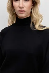 Sweater de punto color negro, con cuello alto y mangas largas de corte raglán.