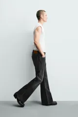 Jeans flare fit de tiro medio, confeccionados en denim de algodón color azul con efecto deslavado. Diseño ajustado en la parte superior y abierto en campana desde la rodilla, con cinco bolsillos y cierre frontal con cremallera y botón.