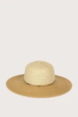 Sombrero de ala ancha confeccionado en fibra natural, color beige, con detalle de cinta metálica dorada alrededor de la copa.