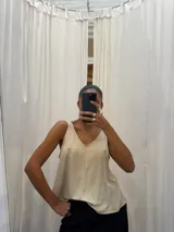 Musculosa negra con acabado satinado y sutil brillo, de corte holgado y diseño básico con breteles anchos.