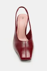 Zapatos de tacón alto en piel color bordó, con diseño destalonado, puntera cuadrada y tacón ancho.