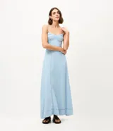 Vestido largo de jean celeste con escote corazón, breteles finos y recortes estructurados en el busto.