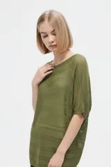 Remera de punto calado color verde militar, de corte holgado, manga corta y cuello bote.