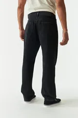 Jean de corte baggy con tiro medio, diseño amplio en piernas y cadera, con cierre y botón frontal.