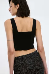 Top tipo corset negro con tirantes regulables mediante lazo delantero y cierre invisible lateral, espalda elastizada con punto smock y corte cropped.