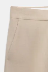 Pantalón de tiro medio con corte recto, bolsillos laterales delanteros y bolsillos de plastrón en la parte trasera. Cuenta con cierre frontal mediante cremallera y gancho metálico.