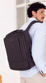 Mochila Lincoln's color negro con diseño rectangular, compartimentos con doble cierre, asas acolchadas, división interna para notebook y puerto USB lateral.
