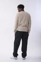 Sweater de punto con diseño de rombos en relieve, color beige jaspeado, de cuello redondo y manga larga.