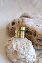 Anillo dorado de bronce con diseño envolvente de tres vueltas.