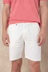 Bermuda de corte clásico en color blanco, con cierre de botón y cremallera, y bolsillos laterales.