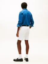 Pantalón corto tipo bermuda color blanco de Tommy Hilfiger, confeccionado en sarga de algodón y elastano. Cuenta con diseño de cuatro bolsillos, cierre de botón con cremallera y cinturón de tejido a contraste incluido.