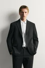 Blazer slim fit de Zara en color negro, confeccionado con mezcla de viscosa. Cuenta con cuello de solapas de muesca, cierre frontal de un botón, bolsillos con solapa en la cadera y un bolsillo de vivo en el pecho.