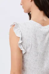 Musculosa blanca con estampado floreado sutil y volados en los hombros, de corte recto.