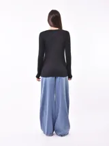 Remera negra de manga larga con estampa de flor en el frente.