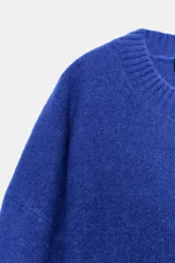 Jersey de punto de tacto suave, color azul eléctrico, con cuello redondo y manga larga. Presenta acabados en rib en cuello, puños y ruedo.