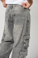 Pantalón cargo baggy de denim en color gris claro, con múltiples bolsillos laterales en las piernas y corte holgado.