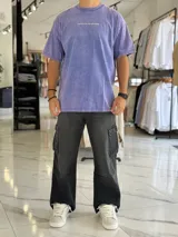 Remera oversize gris con efecto gastado, mangas cortas y estampa con texto blanco en el frente y en la espalda.