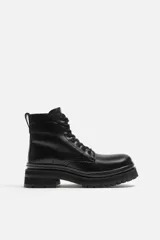 Bota negra de cuero con cordones, caña media y suela track.