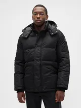 Campera puffer negra con capucha desmontable, cierre frontal con botones a presión y bolsillos laterales. Cuenta con puños internos acanalados para mayor protección contra el frío.