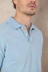 Chomba azul de piqué de algodón con cuello polo, tapeta de dos botones con diseño estampado en el interior y mangas cortas. Corte clásico.