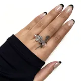 Anillo plateado con forma de serpiente enroscada.