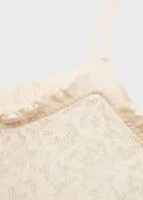 Vestido largo de tejido de punto fino con diseño entallado, tirantes finos y cuello escotado. Presenta detalles calados en toda la prenda y terminaciones con volantes en el escote.