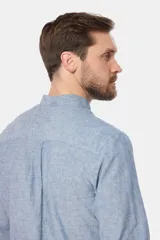 Camisa de lino color beige con cuello mao, manga larga, cierre frontal de botones y bordado sutil en el pecho.