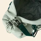 Bolsa de deporte color verde claro, con correas de hombro tipo cuerda, correa ajustable extraíble y sistema de cordones elásticos en el frente para sujeción.