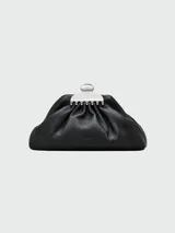 Clutch de mano Marc Jacobs modelo The Small Claw Clip, confeccionado en cuero negro con cierre superior metálico que simula un clip de pelo. Diseño minimalista y estructurado.