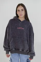 Canguro negro con capucha y bolsillo delantero tipo canguro. Estampa frontal con la frase "Wear More & Worry Less" en color rosa.