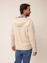 Campera de nylon con cierre frontal, capucha ajustable con cordones y forro interior a cuadros. Presenta bolsillos laterales y logo bordado en el pecho.