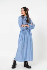 Vestido largo a rayas verticales azules y blancas, con manga globo y diseño de nido de abeja con hilo elástico hasta la cintura. Cuello alto fruncido y falda amplia con caída fluida.
