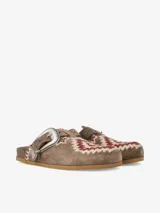 Zueco de gamuza negra con plantilla anatómica y hebilla metálica grande de estilo western. Cuenta con detalles bordados en zigzag de colores en la capellada y el empeine.