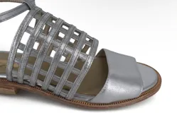 Sandalias plateadas de cuero metalizado con diseño de tiras entrelazadas en el empeine y pulsera al tobillo.