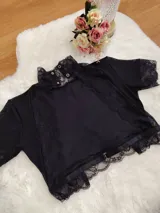 Top de cuello alto confeccionado en terciopelo acanalado, con detalles de encaje en el cuello y el ruedo, y mangas cortas de microtul transparente.